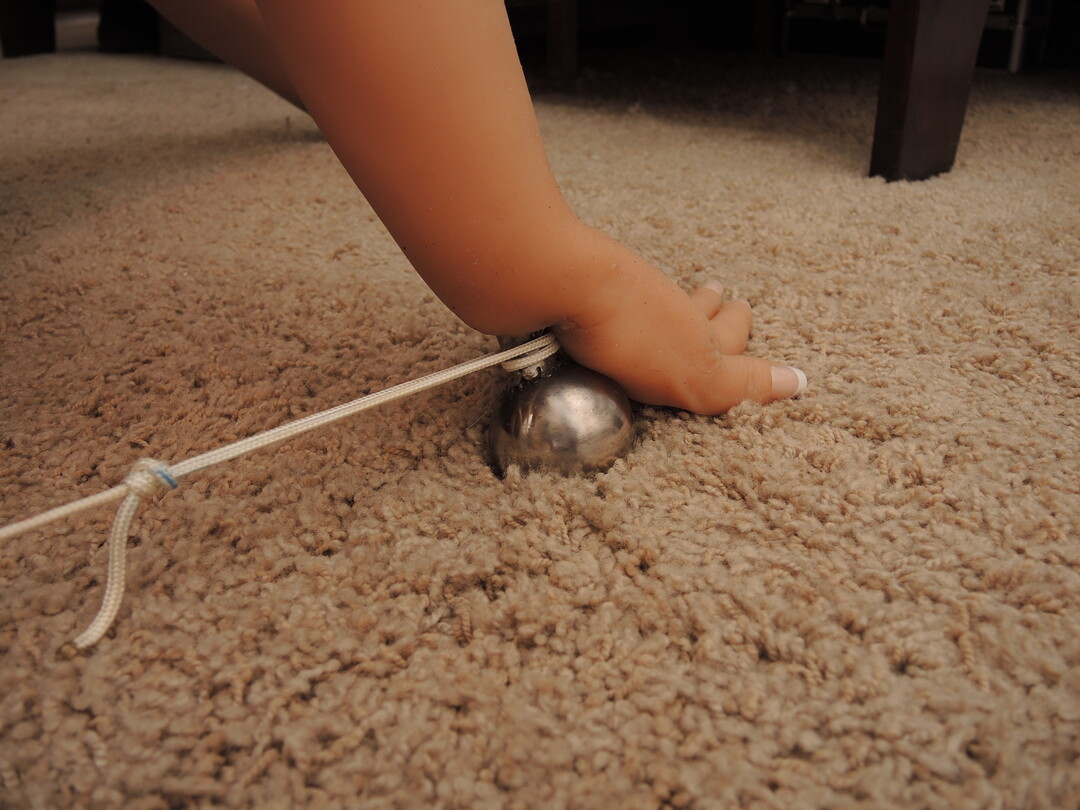 Stainless ball welded to her wrists.