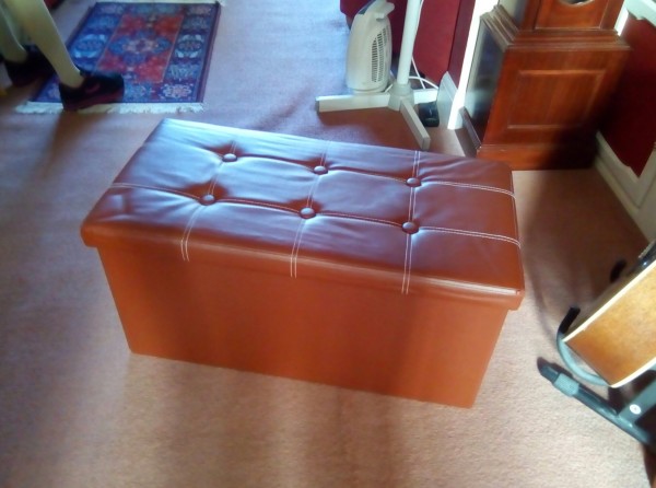 Leather look collapsible ottoman storage.