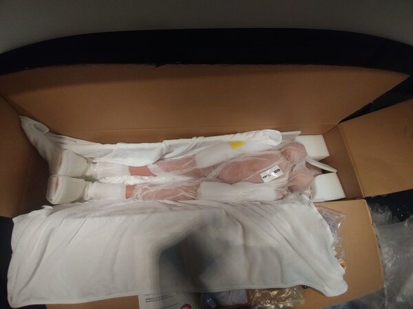 Comfy blanket opened, revealing doll in protective body sleeve.